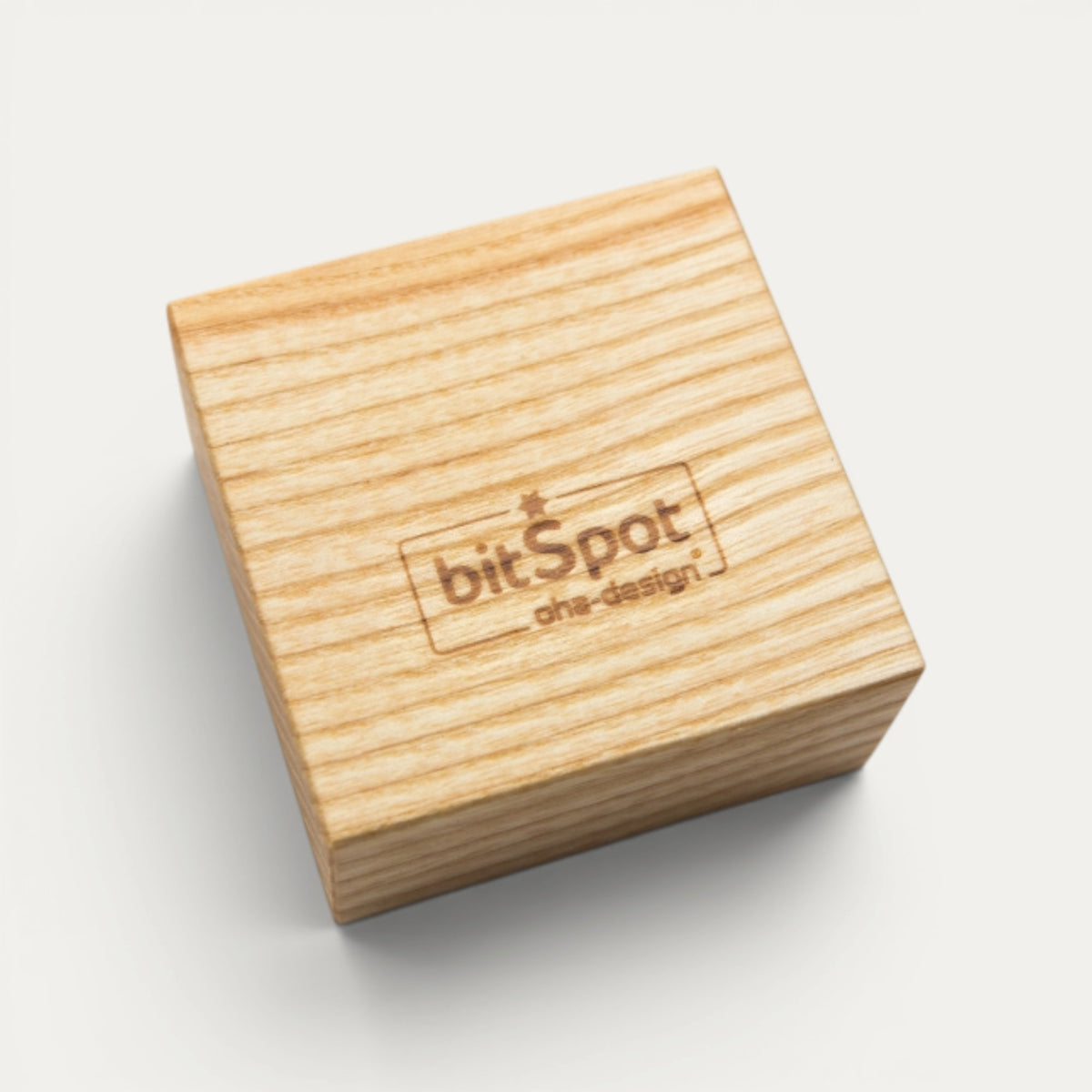 Würfelförmiges Werkzeug-Objekt aus Esche mit eingraviertem bitSpot-Logo als Beispiel für eine Individualisierung